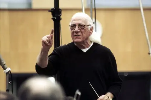 jerry goldsmith Born on February 10, 1929, Jerry Goldsmith studied piano with Jakob Gimpel and composition, theory, and counterpoint with Mario Castelnuovo-Tedesco. He also attended classes in film composition given by Miklós Rózsa at the Univeristy of Southern California. In 1950, he was employed as a clerk typist in the music department at CBS. There, he was given his first embryonic assignments as a composer for radio shows such as "Romance" and "CBS Radio Workshop". He wrote one score a week for these shows, which were performed live on transmission. He stayed with CBS until 1960, having already scored Além da Imaginação (1959). He was hired by Revue Studios to score their series Thriller (1960). It was here that he met the influential film composer Alfred Newman who hired Goldsmith to score the film Sua Última Façanha (1962), his first major feature film score. An experimentalist, Goldsmith constantly pushed forward the bounds of film music: O Planeta dos Macacos (1968) included horns blown without mouthpieces and a bass clarinetist fingering the notes but not blowing. He was unafraid to use the wide variety of electronic sounds and instruments which had become available, although he did not use them for their own sake.